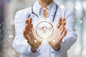 The doctor shows the icon of the female uterus on blurred background.